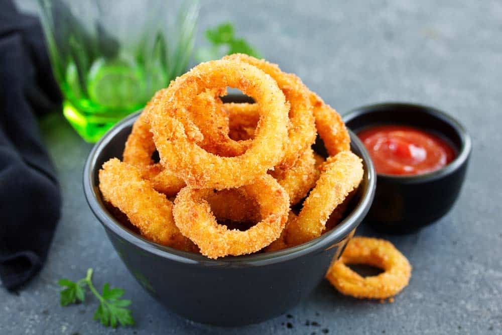 Aros de cebolla rebozados y crujientes con salsa